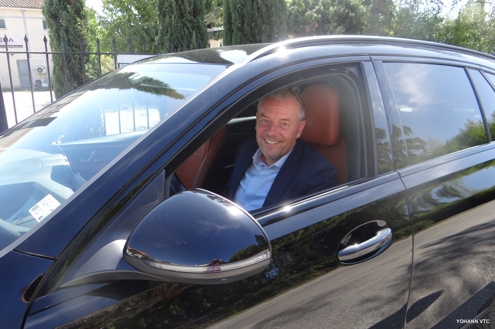 Yohann au volant, vitre ouverte, sièges en cuir cognac de la Mercedes